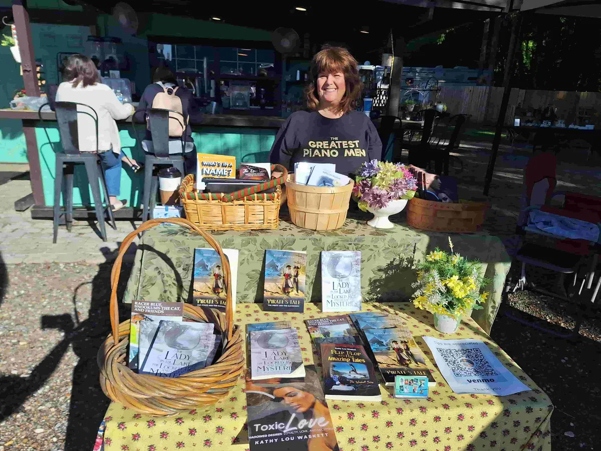 Kathy Lou signing books at a market table