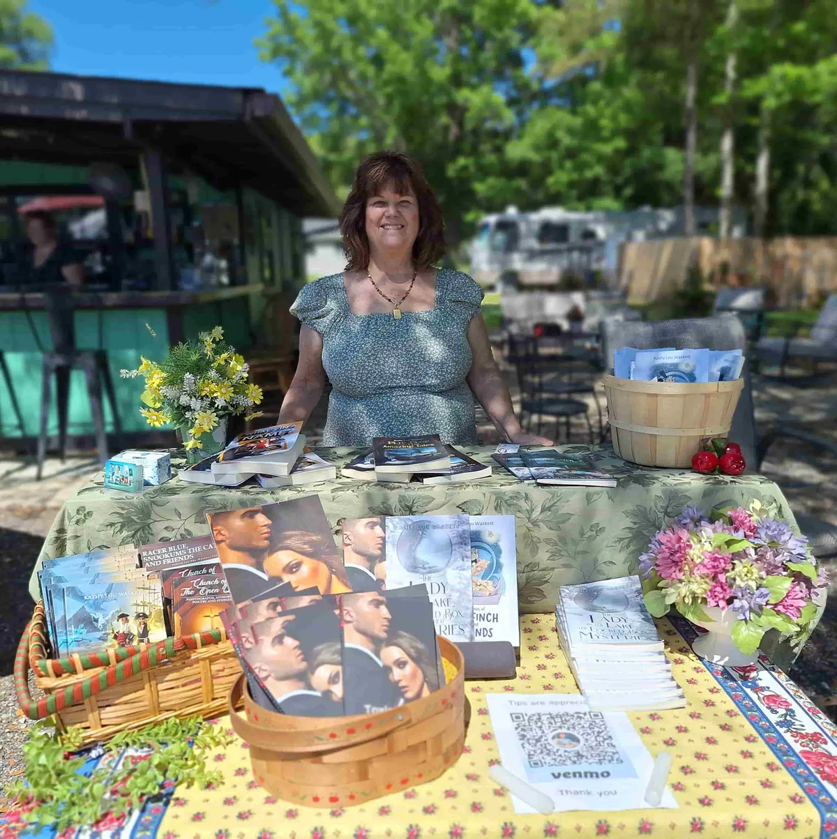 Kathy Lou at her book table at an outdoor market